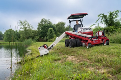Crew trimming the edge of a pond with a Ventrac boom arm